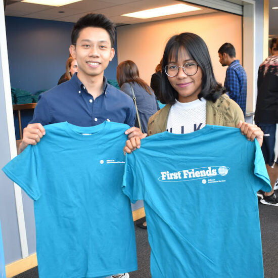 two UIC international students holding first friend blue shirts