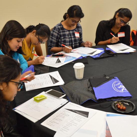 UIC international students sitting at a table writing on paper in workshop and training