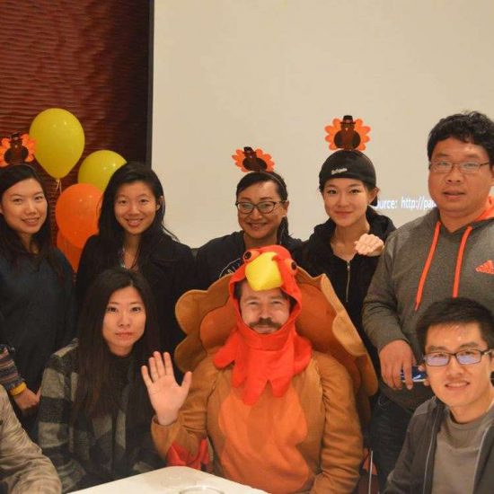 UIC international students wearing turkey headbands at thanksgiving event posing for camera